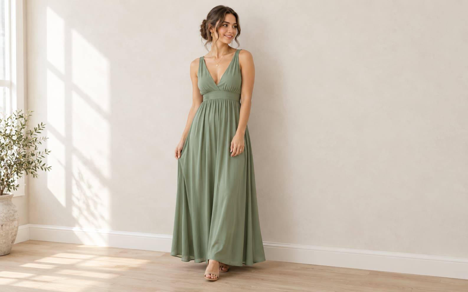 Petite woman in a solid sage green V-neck maxi dress with nude block heels.